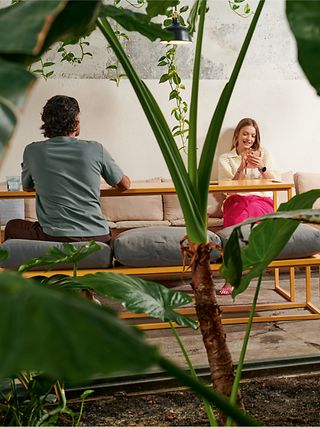 Zwei Personen arbeiten in einem modernen Büro voller Grünpflanzen.
