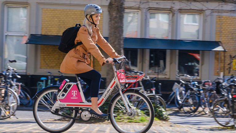 Female cyclist on DB rental bike with Telekom logo