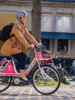 Female cyclist on DB rental bike with Telekom logo