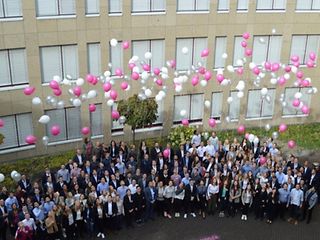 Große Gruppe Studierende lassen Luftballons im Freien fliegen