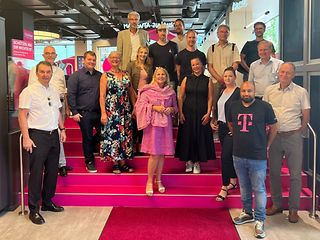 Sabine Wittlinger und Ömer Caliskan stehen mit den Gästen im Eingang des Flagship Store Stuttgart.