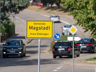 Gelbe Ortseingangsschild von Magstadt, im Hintergrund eine belebte Straße.