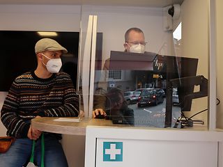 Im Innern des Trucks berät ein Mitarbeiter einen Kunden am Laptop.