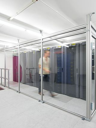 Im Rechenzentrum. Viele Serverschränke und ein Mensch mit Bewegungsunschärfe. 