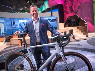 An employee with a road bike on the stand at their Showcase.