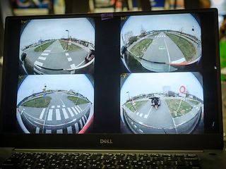 Vier Kameraeinstellungen auf einem Bildschirm die eine Straßensituation zeigen.