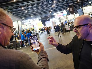 Ein junger Mann erklärt dem Blogautor eine Augmented Reality App auf einem Smartphone.