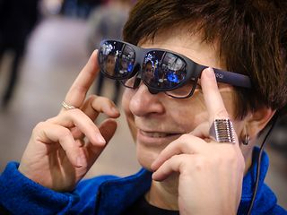 A portrait of a woman wearing augmented reality glasses.
