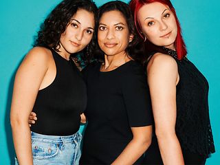 Drei Frauen stehen zusammen und schauen in die Kamera