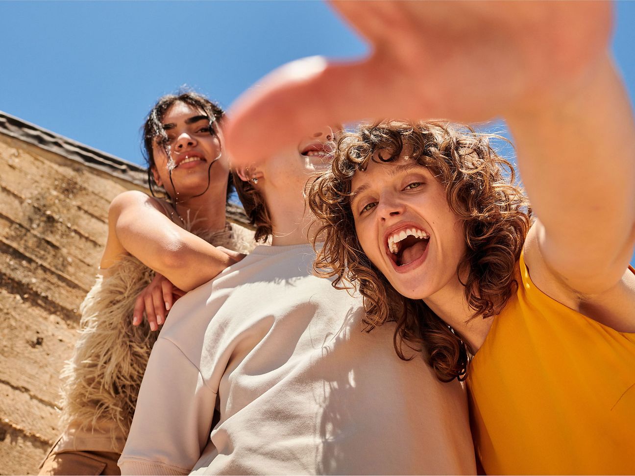 A group of three young people have fun together in front of the camera.