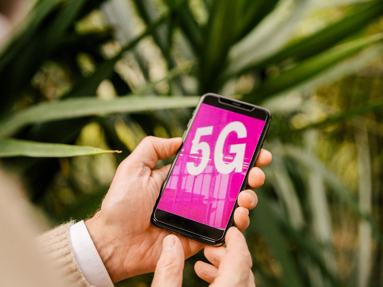 A hand is holding a 5G smartphone