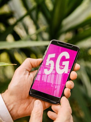 A hand is holding a 5G smartphone