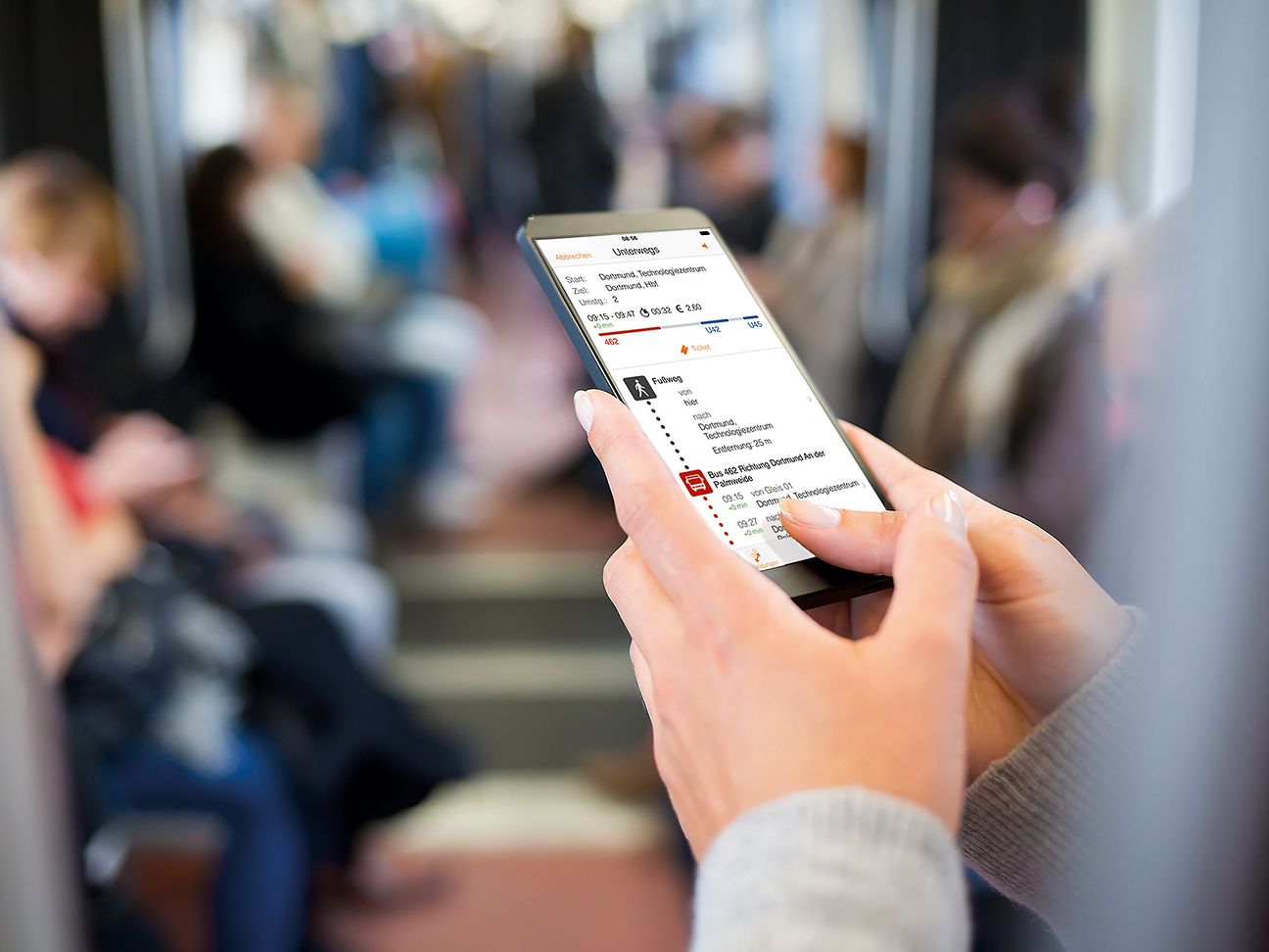 Fahrgast blickt auf Handy-App.