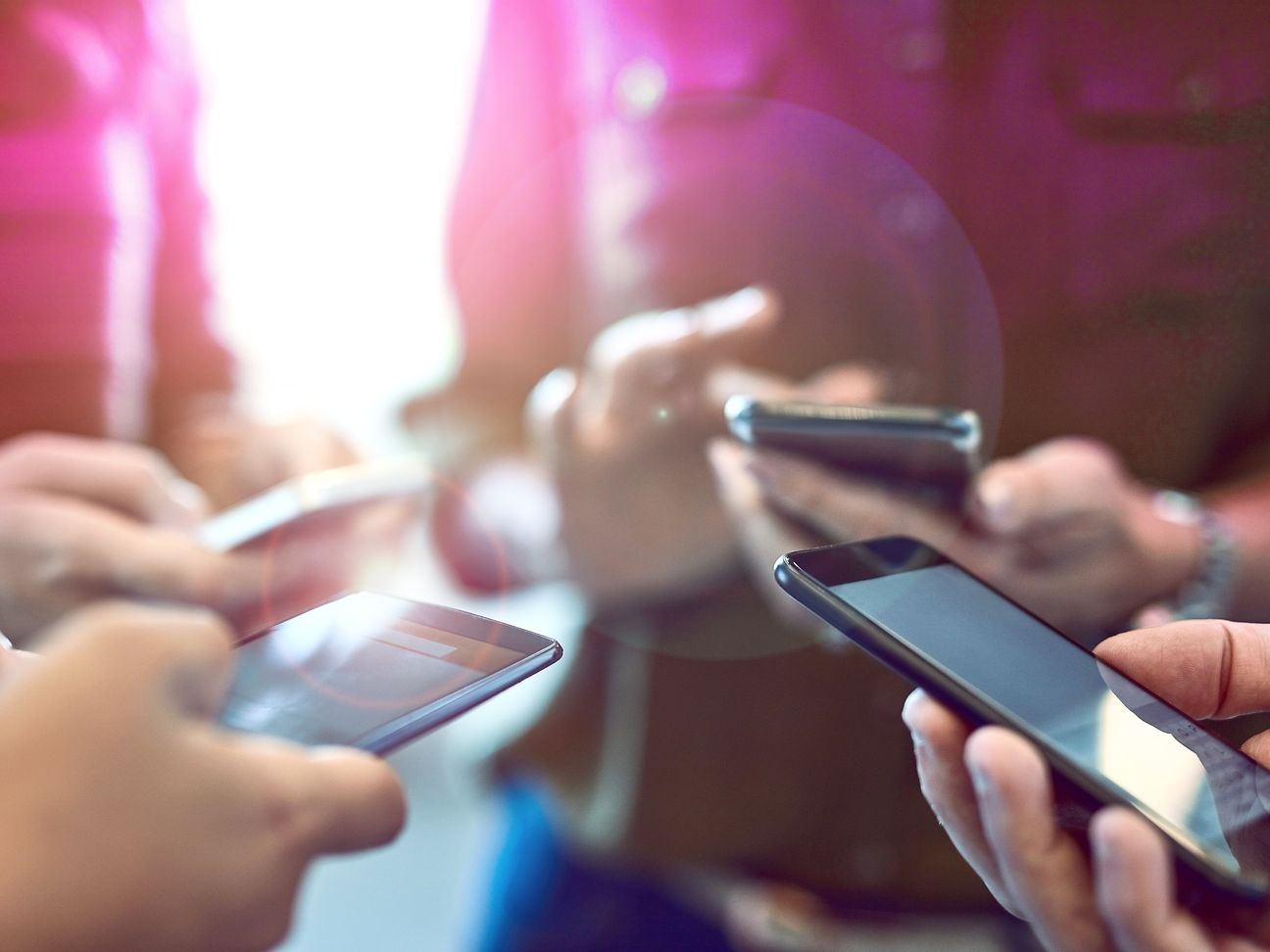 Vier Hände, die jeweils ein Smartphone halten.