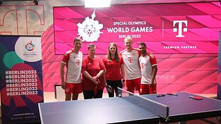 Thomas Müller, Katrin Kerkau, Sina Schellenberger, Matthijs de Ligt und Serge Gnabry hinter einer Tischtennisplatte. 
