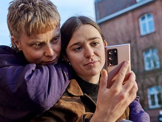Junges Paar schaut bedrückt auf Smartphone
