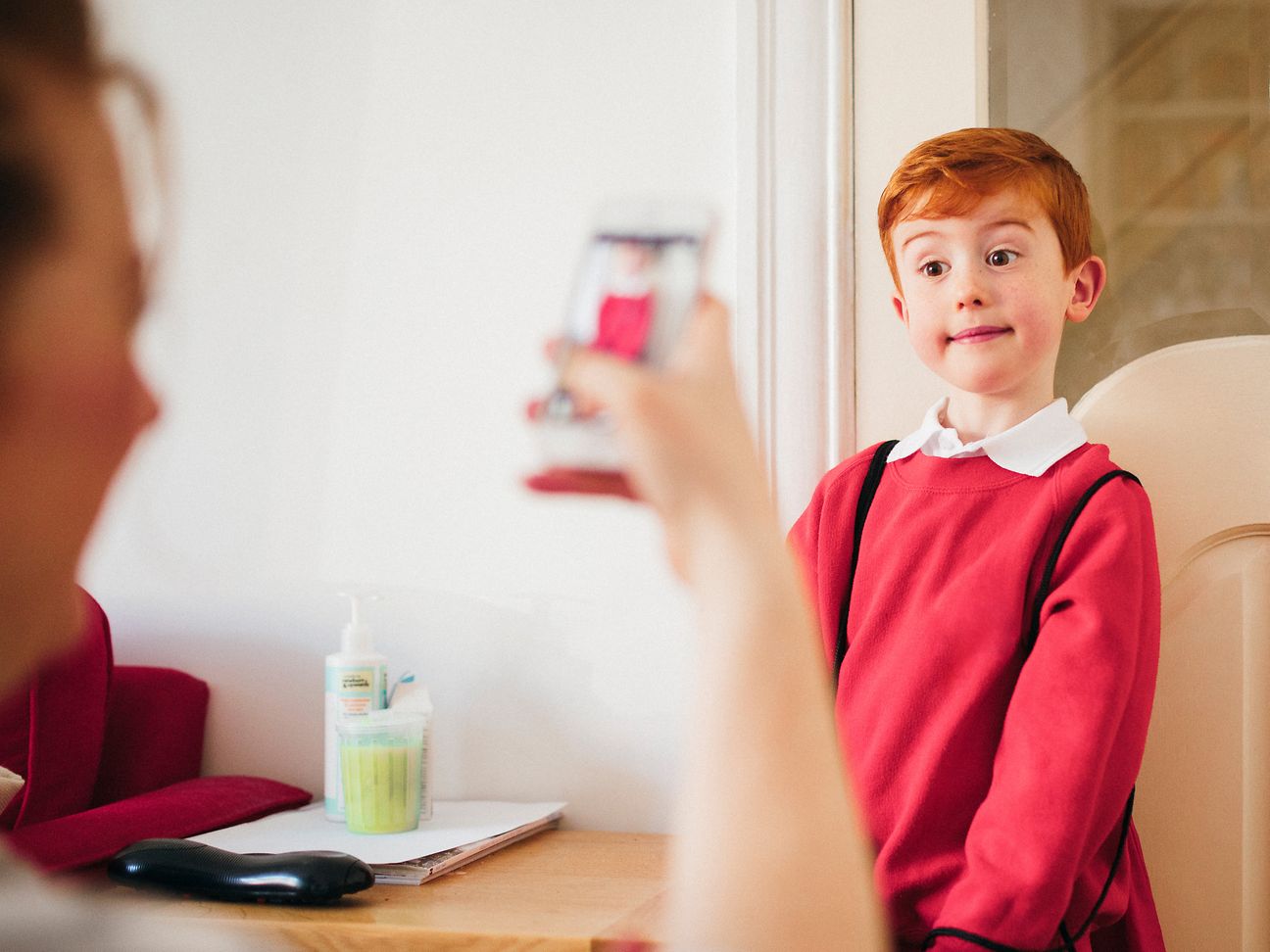 Mother takes a picture of her child with her cell phone.
