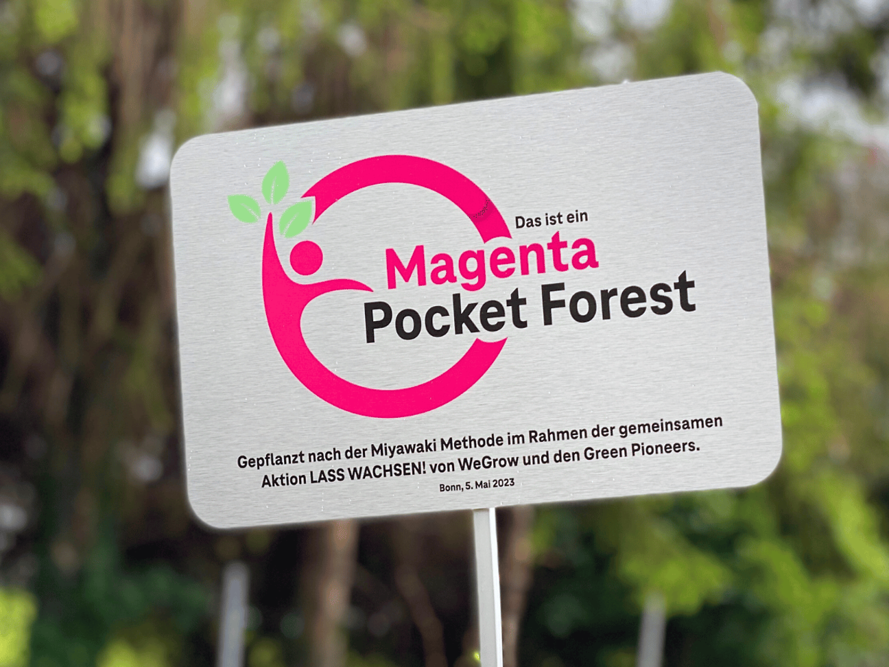 Ein Schild LASS WACHSEN! von WeGrow und den Green Pioneers.