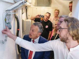 Projektleiter Marius Hihn zeigt, wie das Glasfaserkabel im Keller es Bürgerhauses angeschlossen wird. 