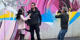 Eine junge Influencerin interviewt einen Auszubildenden von der Telekom auf einem Basketballplatz