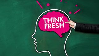 Männliche Hand hält ein Schild als Gehirn mit Aufschrift Think fresh ins Bild.