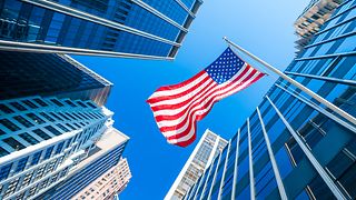 Symbolfoto mit US Flagge vor blauem Himmel