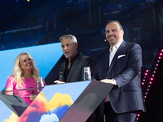 Schauspieler und Filmemacher George Clooney, Moderatorin Barbara Schöneberger und Hagen Rickmann auf der Bühne.