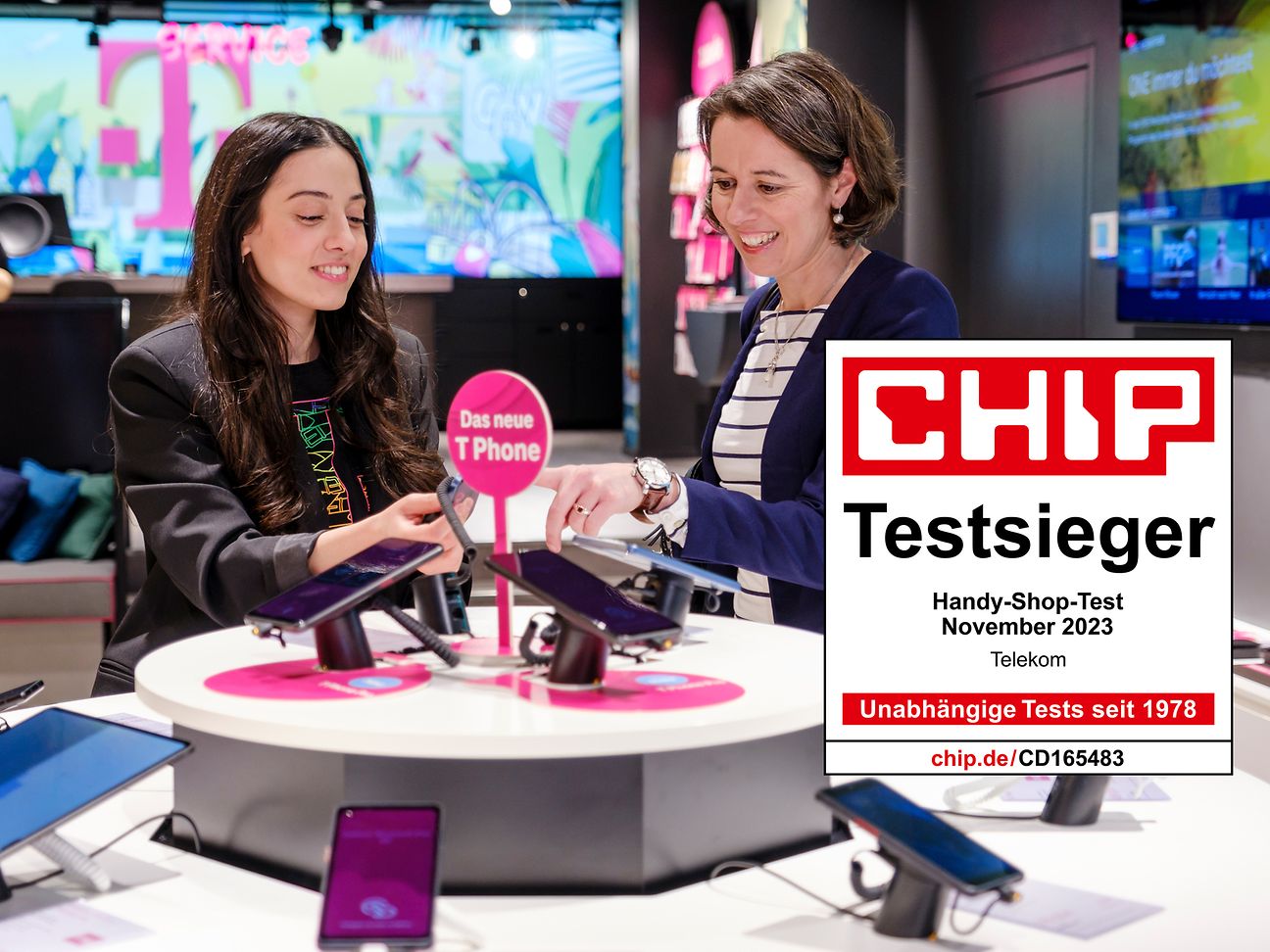 Eine Mitarbeitende im Kundenservice der Telekom und eine Kundin stehen in einem Telekom Shop.