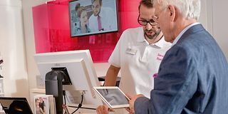 Telekom Mitarbeiter bedient einen Kunden im Telekom Shop.