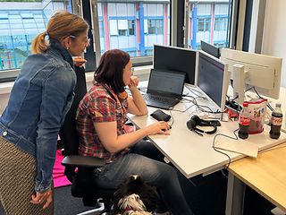 Two women looking at a PC monitor.
