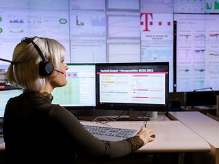 A woman with a headset works on her computer