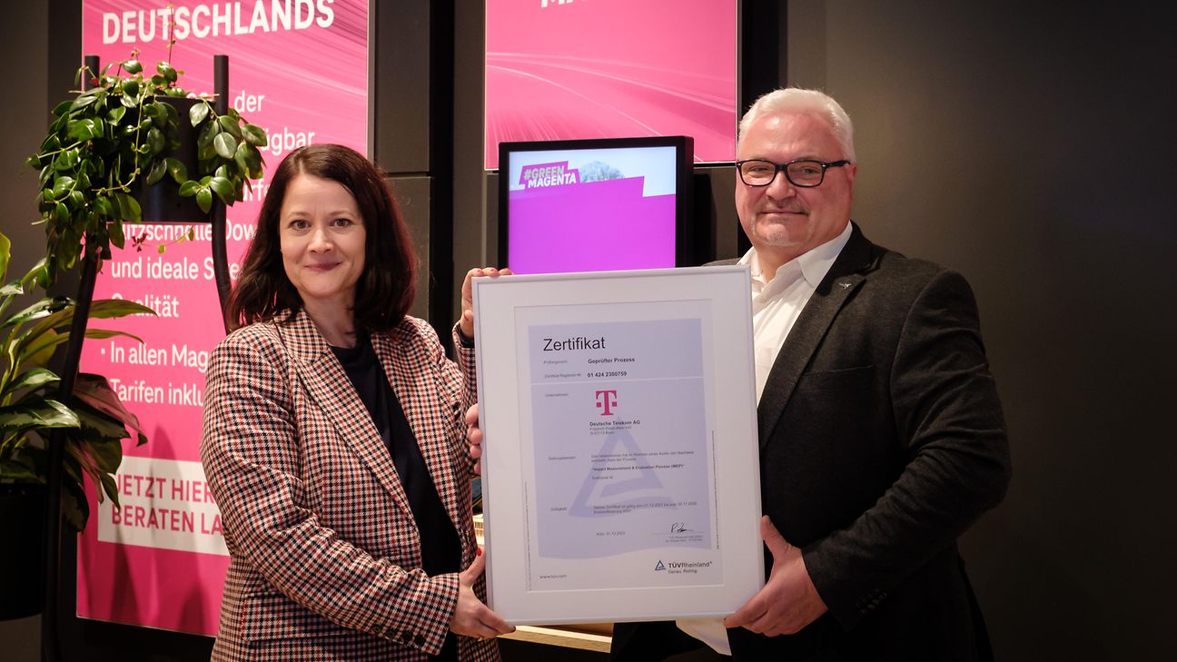 Two people and a framed certificate.