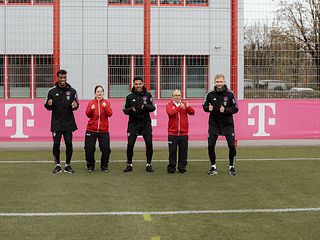 Patricia Schramm und Daniel Pausch beim gemeinsamen Tanzen auf einem Fußballfeld in München mit den drei Fußballspielern vom FCB