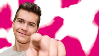 A young man points to you against a magenta and white background