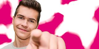 A young man points to you against a magenta and white background