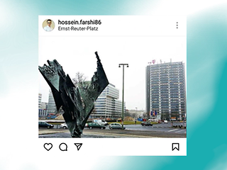 Picture of the Ernst-Reuter-Platz with a sculpture in the foreground and a high-rise with a T logo in the background