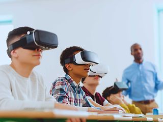 Mehrere Schüler im Unterricht, die je eine VR-Brille tragen.