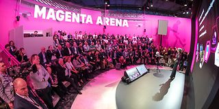 Stage on which a woman stands, with an audience