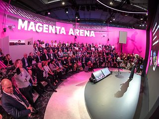 Stage on which a woman stands, with an audience