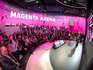 Stage on which a woman stands, with an audience