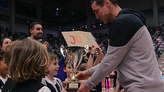 Telekom Baskets Headcoach Roel Moors bei der Übergabe des Siegerpokals an die Kinder der Josefschule.