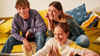 Bild mit Jugendlichen auf dem Sofa beim Fernsehschauen. Logos der Deutschen Telekom und Netflix in rechter unterer Ecke.