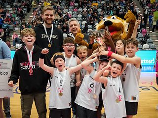 Schülerinnen und Schüler der Kettelerschule jubelnd im Pulk mit dem Siegerpokal. 