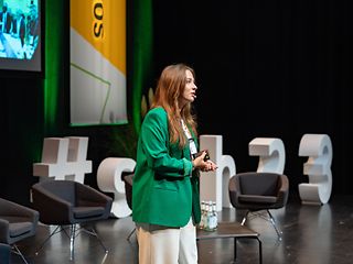 Großaufnahme einer jungen Frau, die einen Vortrag bei einer Konferenz hält.