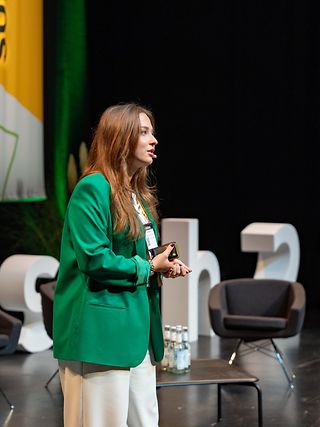 Close-up of a young woman giving a presentation at a conference.