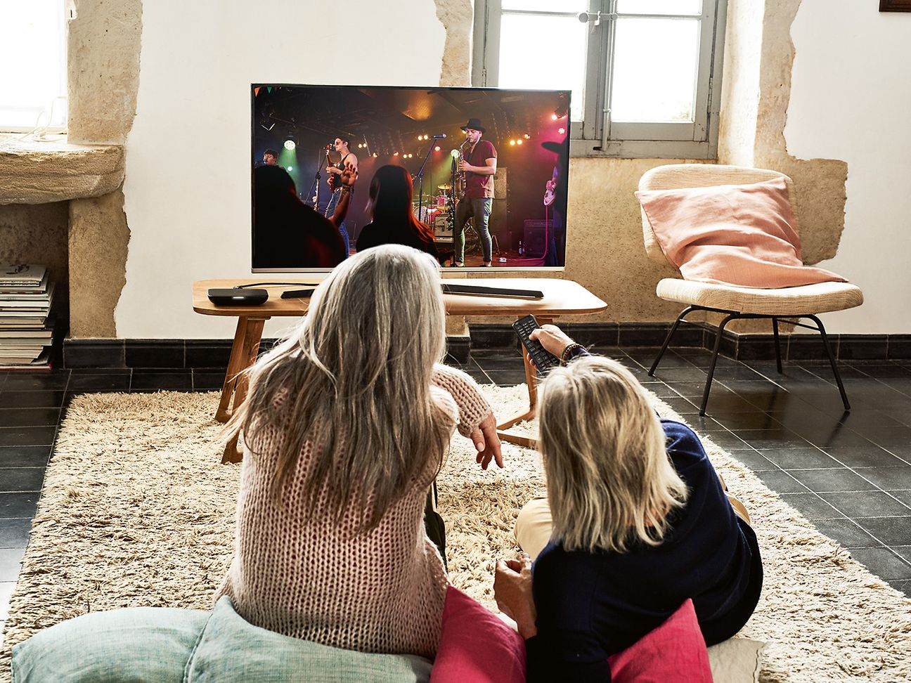 Menschen sitzen vor dem TV und gucken eine Sendung an