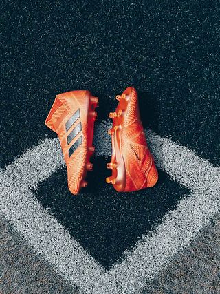 Ein Paar orangfarbende Fußballschuhe