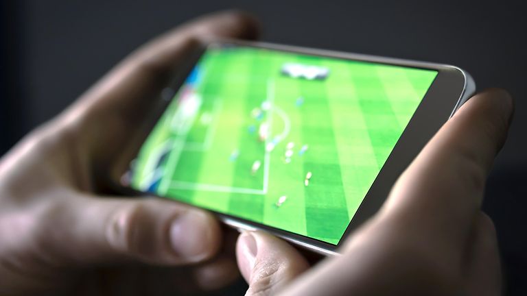 Handy, auf dem ein Fußball-Spiel läuft.