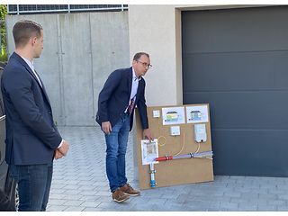 Thomas Meier steht vor einer Demo-Wand und erklärt die einzelnen Bauabschnitte beim Glasfaserausbau.