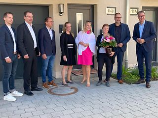 Kundin Louisa Bucher mit Blumenstrauß, umgeben vom Landrat, sowie Vertretern von Stadt, Stadtwerken und Telekom.